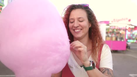 happy-woman-eating-cotton-candy-at-the-fair
