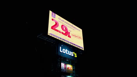 Camera-tilts-revealing-a-LED-Billboard-of-Lotus's-with-KFC-and-MK-plus-the-advertisement-going-on-the-screen,-Thailand