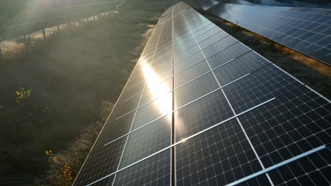Drone-shot-slow-over-a-photovoltaic-cell,-on-a-cold,-fall-evening-on-a-solar-field