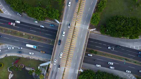 Aerial-drone-shot-looking-straight-down-on-a-busy-intersection-highway-bridge-with-lots-of-traffic-and-green-surroundings-in-Mexico