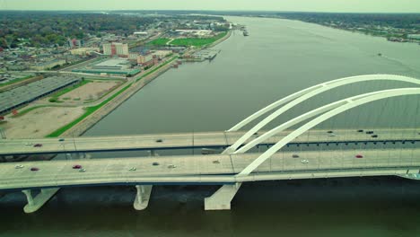 Aerial-video-of-Mississippi-river-Centennial-bridge-and-passing-cars-on-it,-USA
