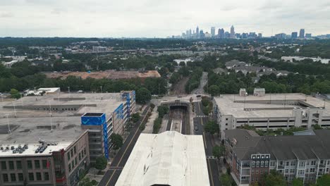 Aerial-approaching-shot-of-Lindbergh-Marta-Station-and-Skyline-of-Atlanta-City-in-background-during-cloudy-day