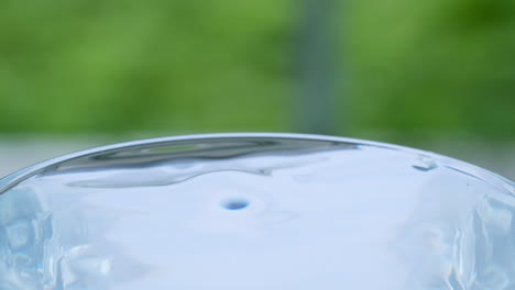 Wassertropfen-Spritzen-In-Ein-Mit-Wasser-Gefülltes-Glas-Und-Erzeugen-Wellen-Und-Wellen