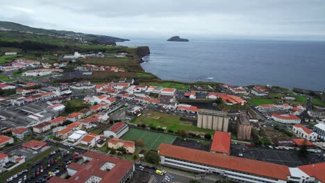 Aerial-flying-backwards-over-football-and-basketball-pitches,-Angra-do-Heroismo