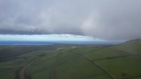 Luftaufnahme-Einer-Nebligen-Und-Wolkenbedeckten-Landschaft-Von-Landwirtschaftlichen-Feldern-In-Serra-Do-Cume,-Azoren
