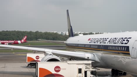 Singapore-Airlines-A350-900-Parkte-Am-Gate-Mit-Einem-Airasia-Flugzeug,-Das-Im-Hintergrund-Auf-Der-Landebahn-Des-Changi-Flughafens-Rollte