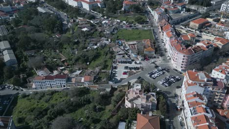 Aerial-view-over-residential-area-with-car-road-traffic-and-red-rooftops-buildings