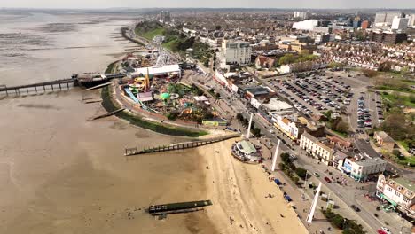 Drone-view-of-Southend-beach-Adventure-Island,-wide-city-shot-reveals-sand,-theme-park,-pier,-residential-beyond