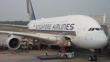 Singapore-airlines-A380-aeroplane-at-terminal,-prepared-workers-using-the-cargo-lift-and-equipment-in-Changi-Airport
