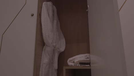 white-bathrobe-hanging-on-rack