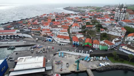 Aerial-tilt-up-from-docked-boats-to-city-of-Sao-Mateus-da-Calheta,-Azores