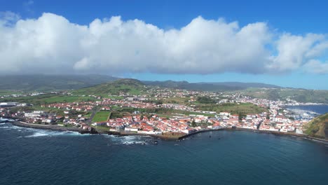 Aerial-parallax-of-Horta-city-with-old-volcanoes-in-background,-Faial-Island