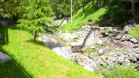 Little-cascade-created-by-overflow-of-dam-in-Sottoguda,-Italy