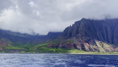 Cinematic-wide-panning-shot-from-a-boat-of-the-lush-Kalalau-Valley-along-the-Na-Pali-Coast-on-the-island-of-Kaua'i,-Hawai'i