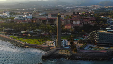Wonderful-aerial-view-in-orbit-near-the-Maspalomas-lighthouse-during-sunset-and-overlooking-the-coast