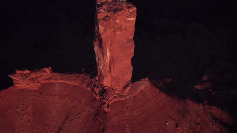 Aerial-flyover-tilts-to-small-peak-of-Moab-rock-spire,-Castleton-Tower