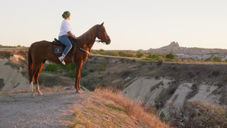 Female-horseback-rider-sunset-valley-overlook-landscape-golden-hour