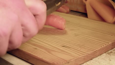 Low-angle-close-up:-Chopping-raw-carrots-on-wooden-cutting-board