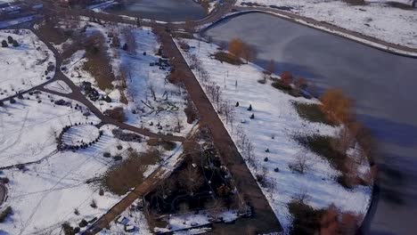 Flying-around-the-park-of-Mogosoaia,-Bucharest,-next-to-a-perfect-frozen-lake