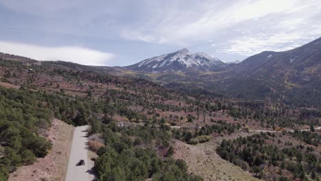 Aerial:-ATV-on-valley-road-near-Moab-Utah,-distant-La-Sal-mountains