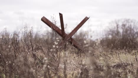 Rusty-old-anti-tank-barrier-in-the-meadow-against-the-sky