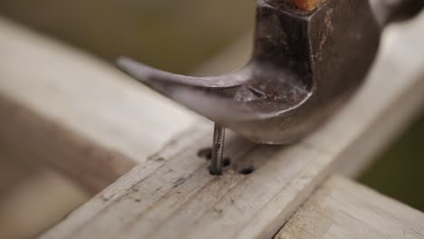 Slow-motion-close-up-of-a-hammer-pulling-a-nail-out-of-wood