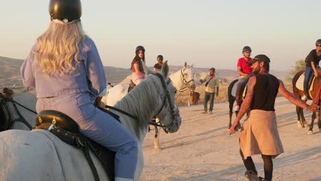 Sunset-horseback-ride-guide-leads-horse-tourist-group-friends