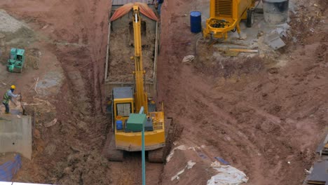 In-Kuala-Lumpur-Malaysia-in-the-pit-excavator-pours-earth-into-a-truck