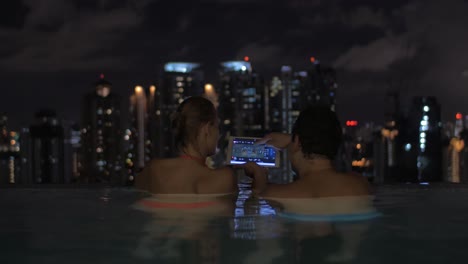 Paar-Mit-Pad-Im-Pool-Auf-Dem-Dach-Von-Nacht-Kuala-Lumpur