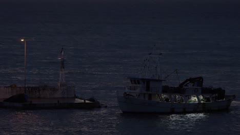In-Nea-Kallikratia,-Griechenland,-Segelt-Das-Schiff-Im-Nächtlichen-Meer-In-Der-Nähe-Des-Leuchtturms-Und-Hält-Am-Pier