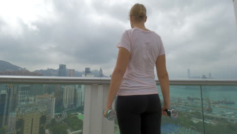 Woman-doing-shoulder-exercises-on-the-balcony-Hong-Kong-China