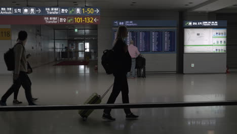 Personas-Con-Equipaje-Caminando-En-La-Terminal-Del-Aeropuerto-De-Seúl,-Corea-Del-Sur.