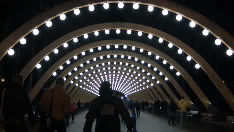People-walking-in-illuminated-walkway-of-Park-Sokolniki-Moscow