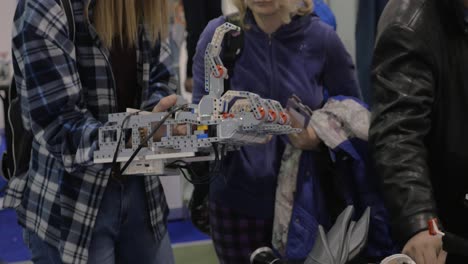 Mädchen-Benutzt-Roboterhand-Auf-Der-Robotics-Expo