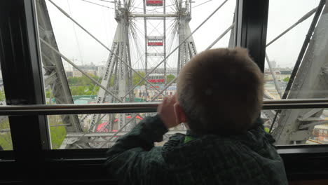 In-Vienna-Austria-from-the-window-booths-of-the-ferris-wheel-little-boy-looks-at-the-city