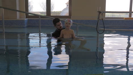 Therapist-and-child-doing-gymnastics-in-pool