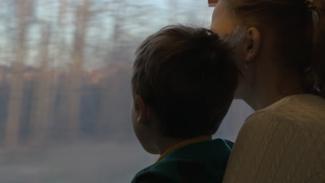 Mutter-Und-Kind-Schauen-Während-Der-Fahrt-Aus-Dem-Zugfenster