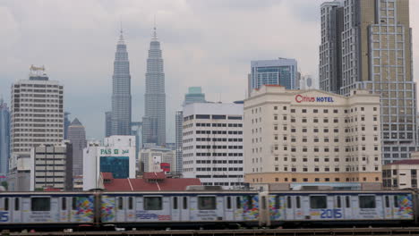 Mit-Der-Bahn-Passiert-Der-Zug-Im-Hintergrund-Das-Petronas-Twin-Towers-Hotel-Und-Die-Wolkenkratzer