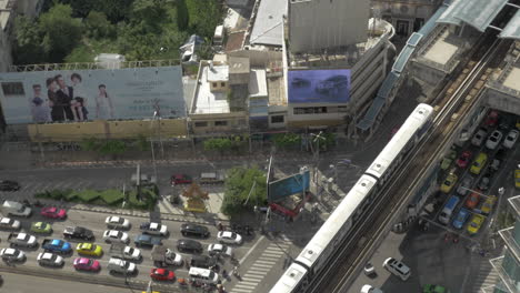Bird-eye-view-of-big-road-with-a-lot-of-cars-trucks-and-moving-train-on-railways