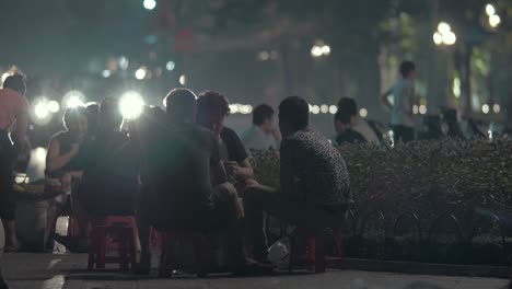 Eine-Gruppe-Junger-Männer-Sitzt-Und-Redet-Nachts-Im-Freien