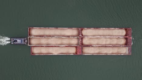 Tow-boat-pushing-hopper-barge-on-Ohio-river,-top-down-drone-full-shot