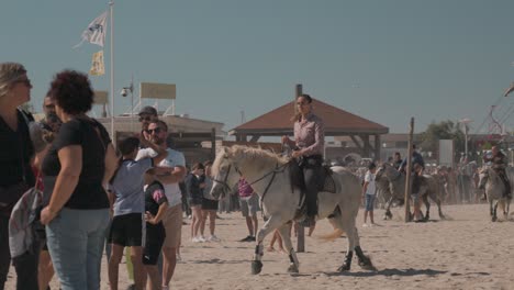 Beautiful-woman-gracefully-commands-Camargue-horse-on-beach-at-Feria-Palavas