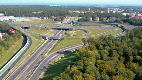 Vista-Aérea-De-Un-Cruce-De-Autopistas-Con-Carreteras-Circulares-Y-Exuberante-Vegetación.