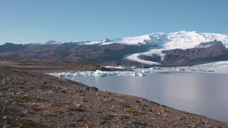 Excursionistas-Caminando-Por-El-Sendero-A-Lo-Largo-Del-Lago-Glaciar-Fjallsárlón-En-Islandia