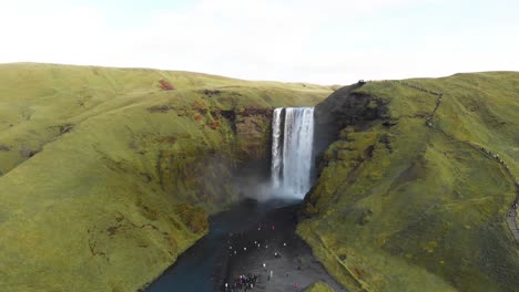 Tosender-Skogafoss-Wasserfall-In-Island-Mit-Touristen,-Die-Ihn-Unten-Bewundern