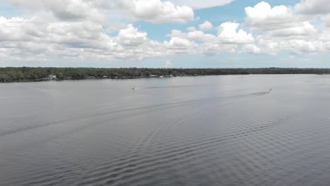 Vista-De-Drones-Cielo-Azul-Nubes-Blancas-Con-Vistas-Al-Agua-Puerto-Deportivo-Lancha-Rápida-Pasando-En-Agua-Velero-Barco-Pescador