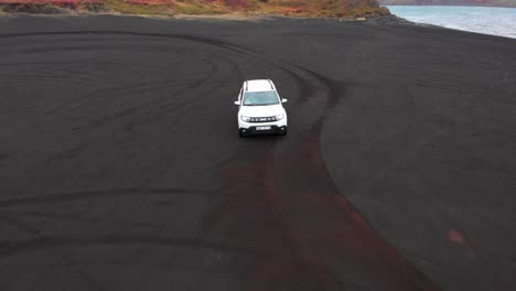 SUV-Blanco-Conduciendo-En-Una-Playa-Volcánica-Negra-En-Otoño-En-Islandia