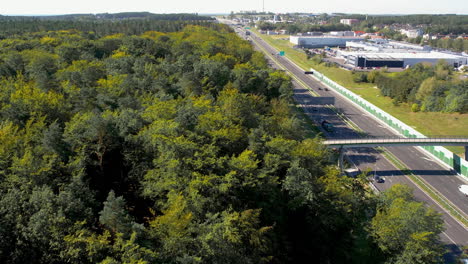 Drone-view-of-a-highway-cutting-through-a-dense-green-forest
