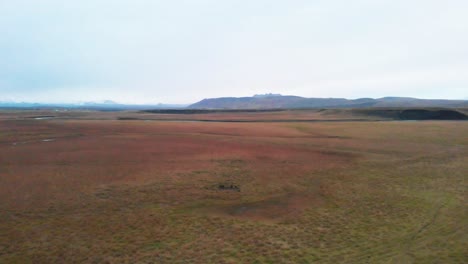 Vast-windswept-plains-in-grassy-nordic-landscape-in-Iceland,-drone