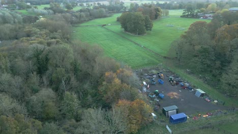 Orbit-aerial-drone-shot-of-an-agricultural-farmstead,-showing-different-farm-implements,-pasture,-backwoods,-animal-paddocks,-stables,-farmhouse,-and-nearby-community-in-Thetford,-United-Kingdom